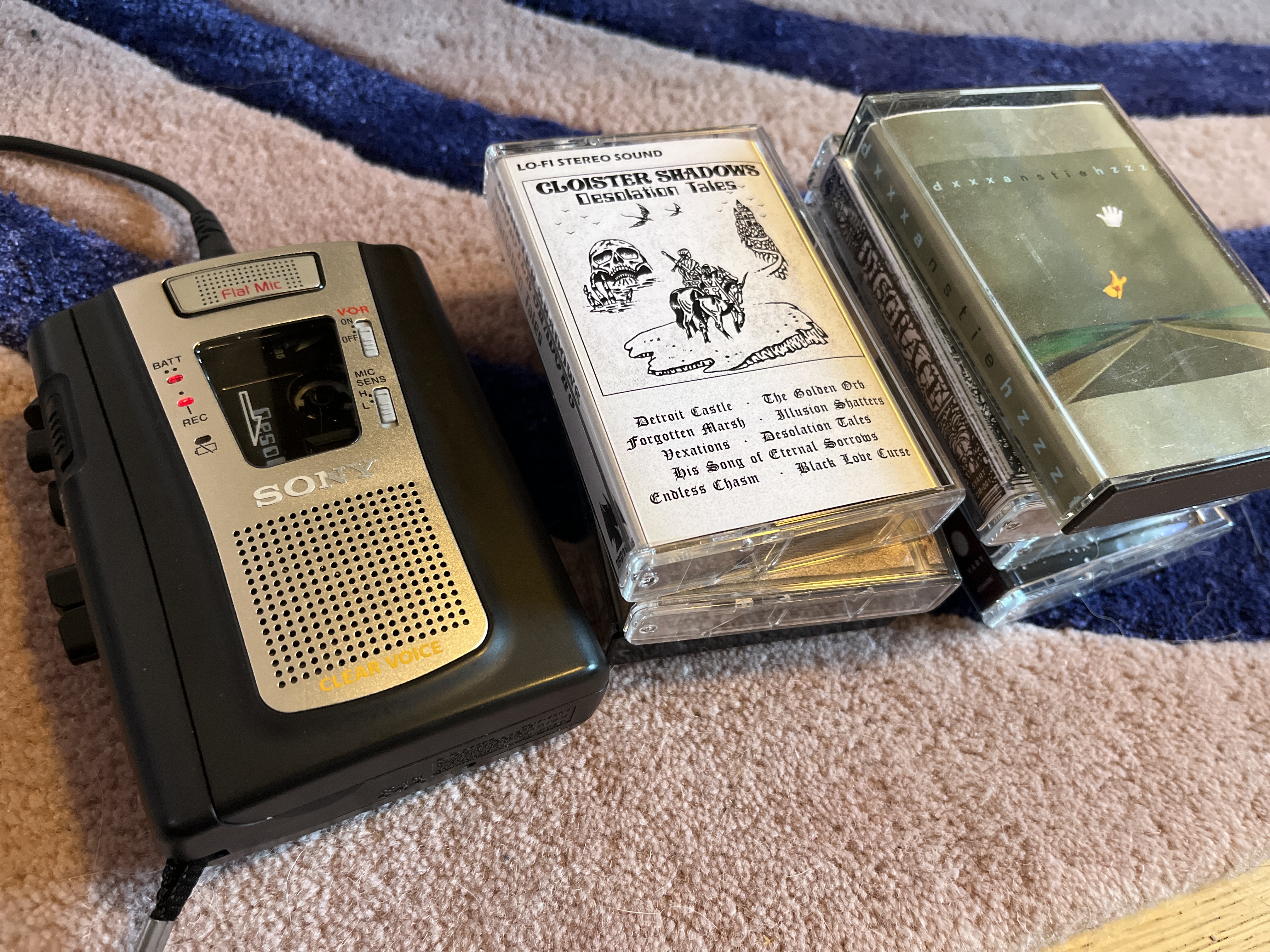 A Sony cassette recorder next to a pile of cassettes